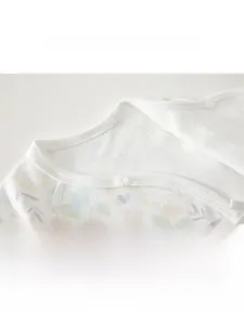 Detail of soft cotton baby shirt collar with delicate floral print and secure snap button