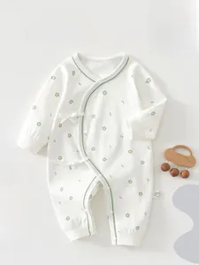 Close-up of baby long-sleeve floral romper with green trim and side-tie closure