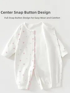 Detail of baby cotton long sleeve romper featuring snap button closure and floral print