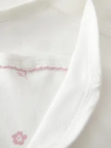 Dettaglio dei bottoni a pressione in resina POM alimentare su vestiti neonato floreali