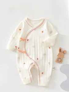 Detail of soft cotton baby romper with animal prints and elegant bow tie closure