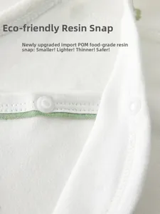Macro detail of eco-friendly POM resin snap buttons on newborn cotton baby bodysuit