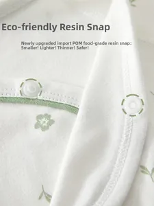 Detail of eco-friendly food-grade resin snap buttons on floral cotton baby romper