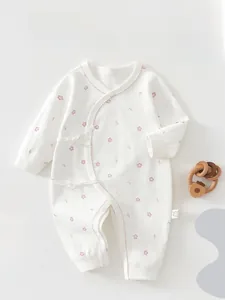 Detail of newborn floral cotton romper with tie-front closure and soft wavy trim