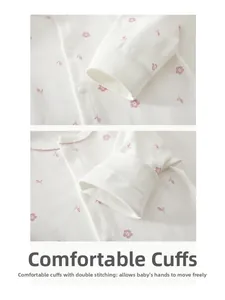 Detail of baby cotton romper featuring pink floral prints and premium ribbed cuffs with snaps