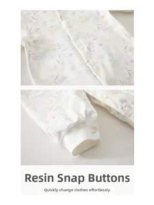 Detailed view of the resin snap buttons and floral cotton fabric on a baby romper