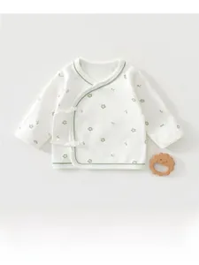 Detail of newborn baby cotton wrap top featuring green floral prints and soft lacing