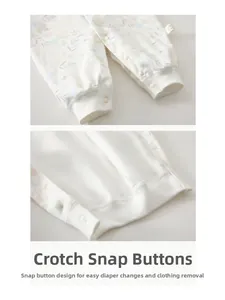 Close-up of snap buttons on the crotch of a floral cotton infant bodysuit for easy changes