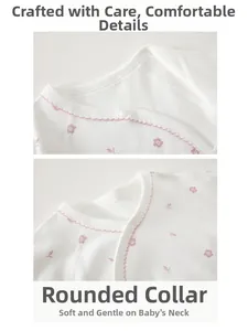 Detailed close-up of baby bodysuit neckline with pink floral print and wavy lace trim