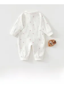 Flat lay of baby floral cotton jumpsuit with ribbed cuffs and wooden teether detail