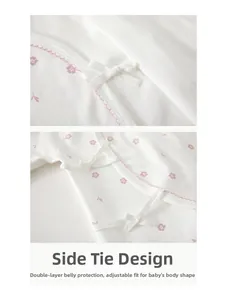 Detail of pink floral cotton baby romper with side-tie closure and double-layer belly guard