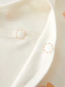 Detail of infant bodysuit showing safe white POM resin snap buttons on combed cotton fabric