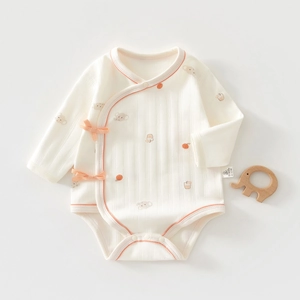 Detail of baby cotton bodysuit with bear patterns and side ribbon ties for newborns