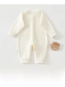 Gros plan d'une grenouillère bébé en coton côtelé avec col rond et anneau de dentition bois