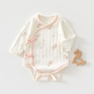 Detailed close-up of baby bodysuit with pink ribbon and cute cartoon bee prints