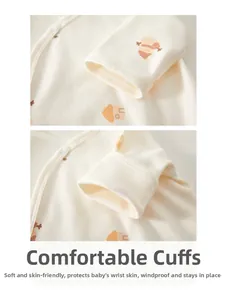 Detail of baby bodysuit elastic ribbed cuffs with cute cartoon print on soft beige cotton