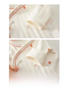 Close-up of soft cotton baby bodysuit cuffs with cute bear and orange pattern detail