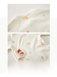 Détail du haut cache-cœur pour bébé en coton bio avec broderie bonhomme de neige et motifs