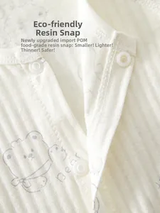 Detail of eco-friendly resin snaps on breathable cotton baby romper with bear print