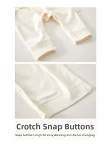 Detail view of snap buttons at the crotch of newborn cotton romper for easy diaper changes