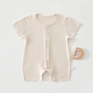 Close-up of beige baby short sleeve bodysuit with snap button closure and side wash label