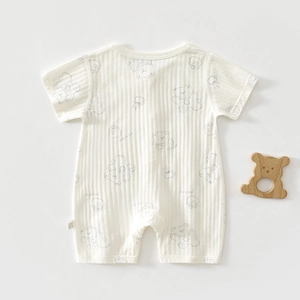 Détail d'un barboteuse bébé à manches courtes en coton côtelé avec motifs d'ours et miel