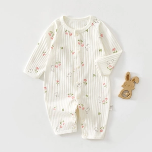 Detailed close-up of white cotton baby romper with cherry print and vertical rib texture