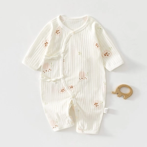 Détail de la barboteuse bébé en coton à fleurs avec texture gaufrée et nœuds latéraux