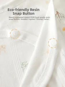 Detail of POM food-grade resin snaps on white knit baby bodysuit with rabbit pattern