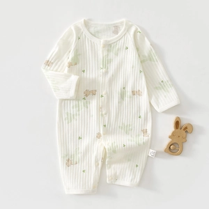 Detail of newborn long sleeve romper with cute rabbit print and wooden rattle prop