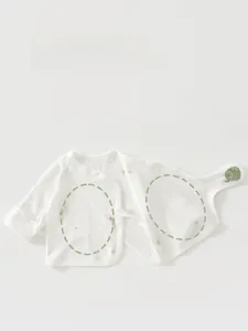 Detail of newborn baby cotton shirt featuring side ties and a cute elephant patch