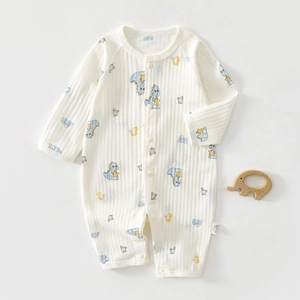 Detail of baby organic cotton romper with cute blue dinosaur prints and snap buttons