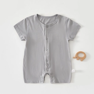 Flat lay of gray cotton baby romper with snap button closure and small wooden toy