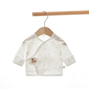 Detail of newborn floral cotton wrap top with cherry embroidery and size 52 labels