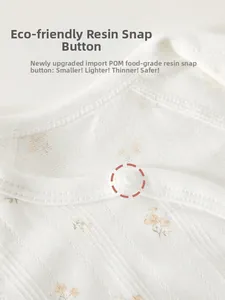 Dettaglio dei bottoni automatici in resina POM su body neonato a fiori in costina