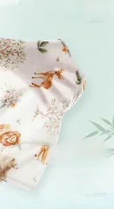 Detail of breathable bamboo cotton fabric with hand-drawn forest animal prints for baby
