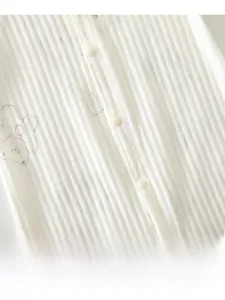 Detail view of baby bodysuit showing ribbed cotton fabric, resin buttons and bear prints