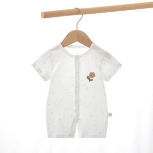 Détail d'un body pour bébé en coton avec broderie florale et fermeture à boutons-pression