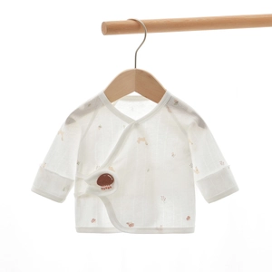 Detailed macro view of thin gauze baby wrap top with delicate leaf and mushroom prints