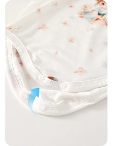 Vue détaillée des boutons-pression et de l'imprimé floral sur le body bébé en coton
