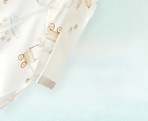 Gros plan d'une grenouillère d'été légère pour bébé avec motifs de voitures et nuages