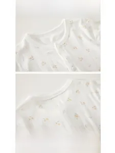 Détail d'un body bébé en coton avec imprimé fleuri et texture de tissu côtelé respirant