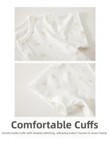 Détail d'un barboteuse bébé en coton avec motif floral jaune et boutons ronds blancs