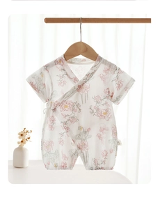 Detail of newborn baby short sleeve romper with soft pink floral and bird patterns