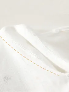 Breathable white cotton newborn romper with jacquard pattern and seamless flatlock stitching