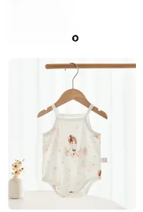 Gros plan d'un body bébé en coton à bretelles avec imprimé floral sur cintre en bois