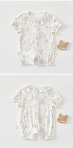Detail of floral baby bodysuit with ruffled collar and soft cotton texture