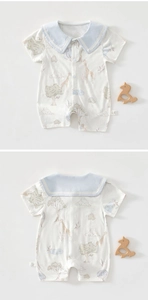Detail of baby cotton romper with giraffe print and sailor collar on a white background