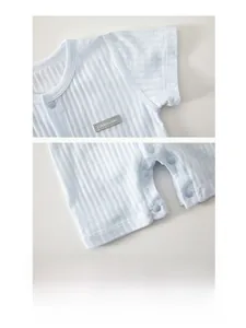 Detail of light blue striped cotton baby romper showing snap buttons and fine stitching