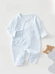 Detail of light blue baby romper with side ties and soft ribbed cotton fabric